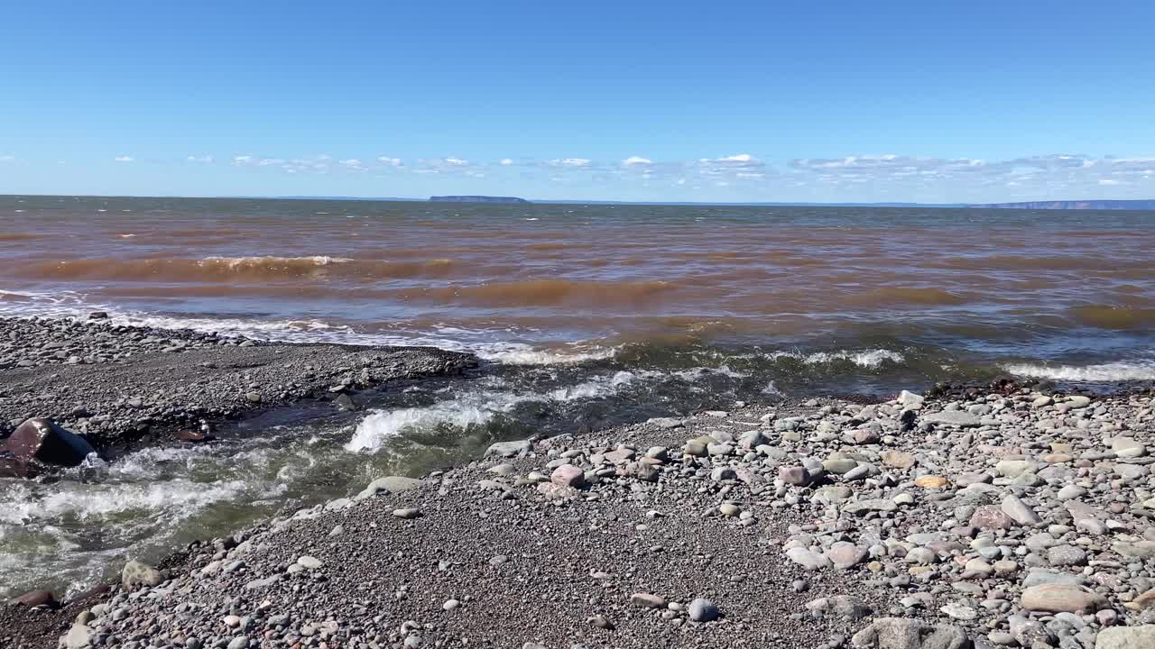 Freshwater river flowing into salty Atlantic Ocean water along high tide coast