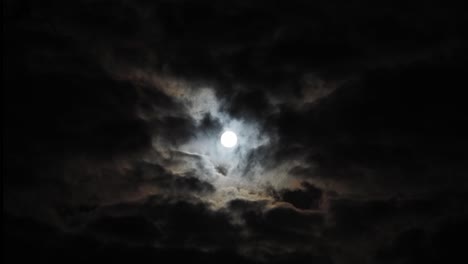 Amplio-Lapso-De-Tiempo-De-Luna-Llena-Que-Sube-Lentamente-Con-Halo-Detrás-De-Las-Nubes,-Copia