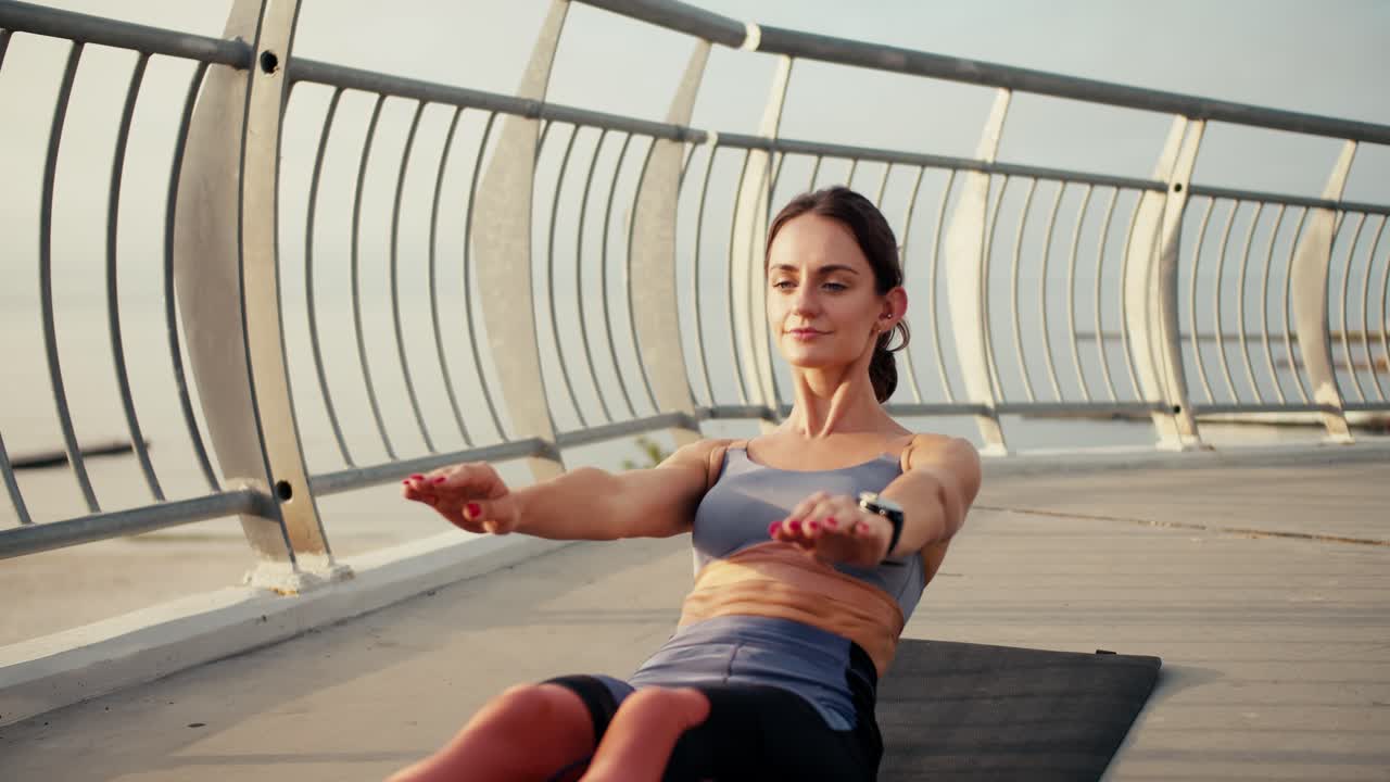 chica feliz en un uniforme especial de verano hace para fortalecer la prensa en una alfombra especial en la calle. ejercicio matutino modo de vida activo