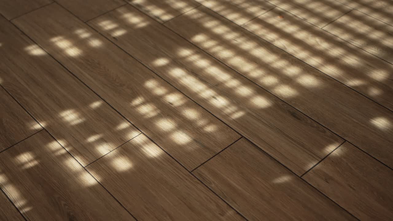 Sunlight filtering through blinds casting geometric light patterns on a wooden floor
