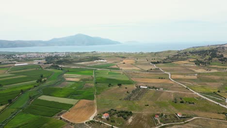 Tierras-De-Cultivo-Situadas-Cerca-Del-Mar-Con-Montañas-Al-Fondo