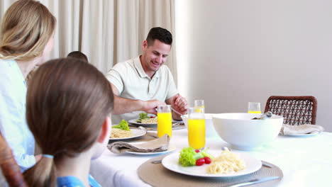 joven familia feliz en la mesa de la cena
