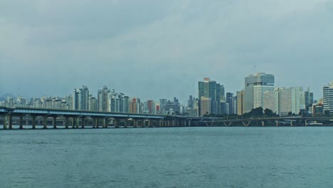 Seoul-City-River-Stadtpark-Mit-Brücke-Am-Abend-Mit-Gebäuden-Und-Wolkenkratzern-Weitwinkelansicht-Panorama-Mit-Wasser,-Wellen-Und-Himmel-Weitwinkelansicht