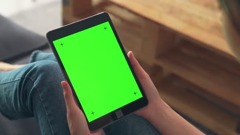 close up de mujer sosteniendo en las manos una tableta digital con pantalla verde para internet en línea, pantalla clave de croma para publicidad.