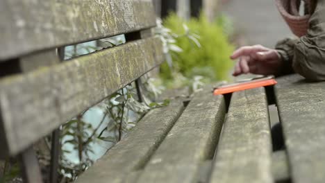 Using-a-smartphone-on-a-rustic-bench