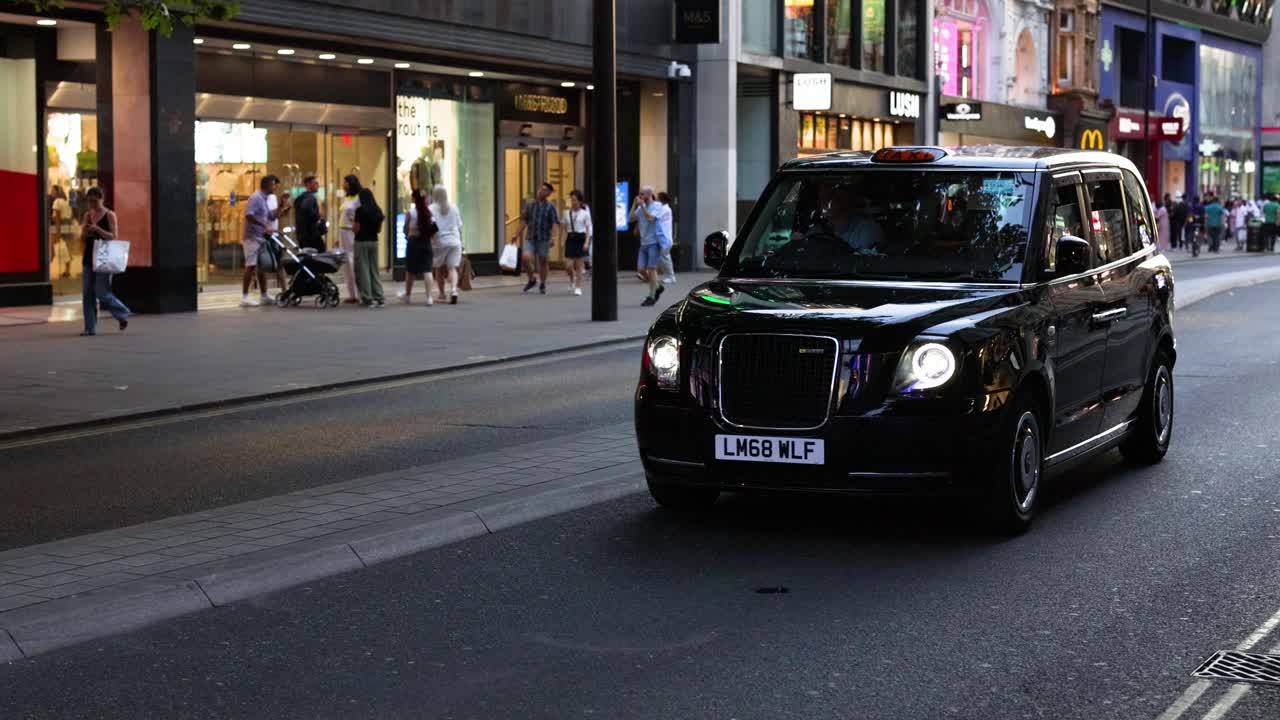 taxi negro conduciendo a través de una concurrida calle comercial