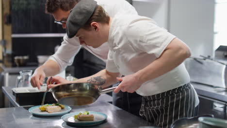 two chefs working together on food orders in restaurant kitchen