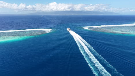 french polynesia. drone shot of ferry boat sailing between coral reefs and moorea and tahiti islands