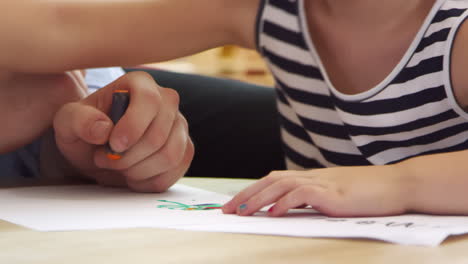 primer plano de un alumno dibujando con lápiz de colores en una clase de escuela montessori
