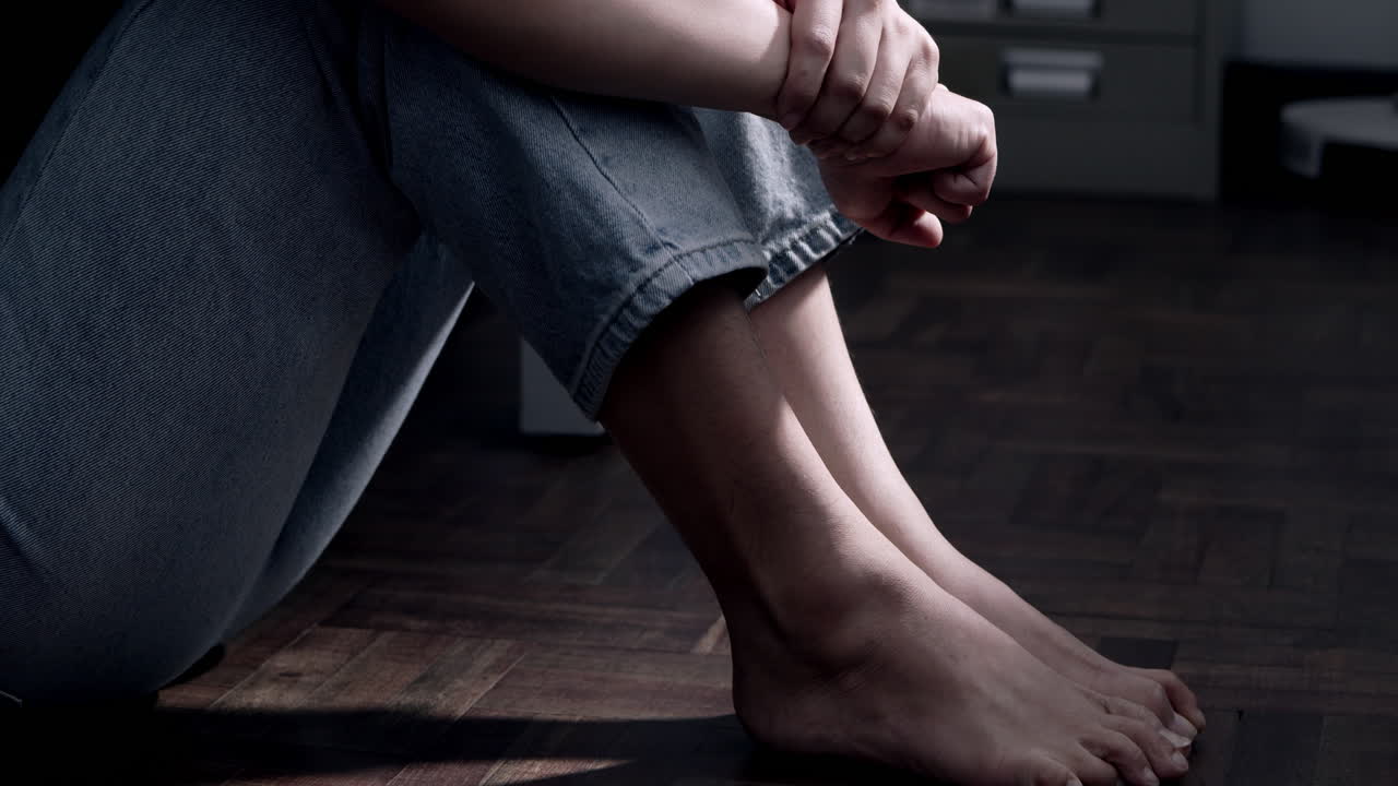 A moment of solitude captures deep emotions while sitting alone in a tranquil indoor environment.