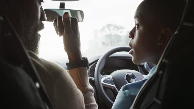 Video di padre afroamericano felice che insegna al figlio a guidare un'auto