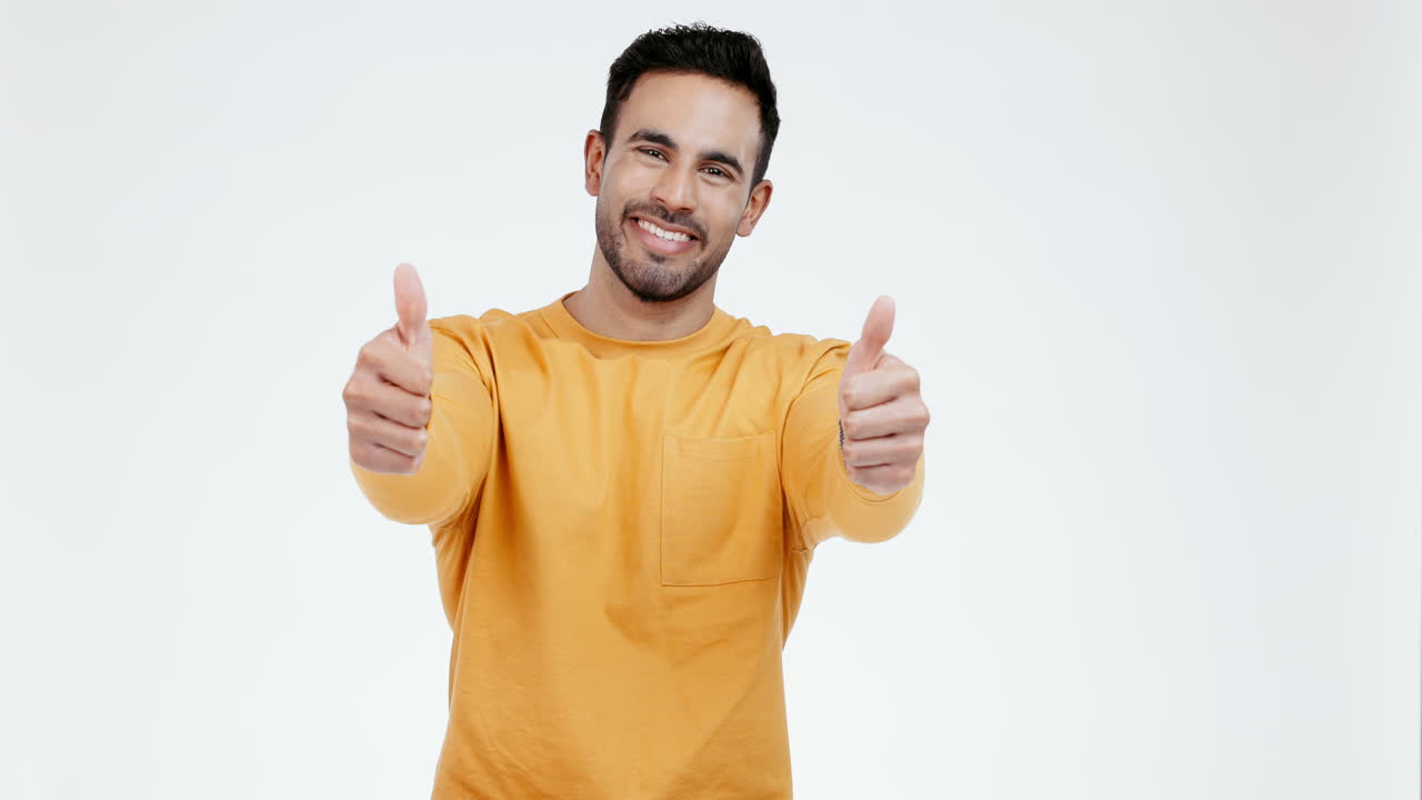 pulgares hacia arriba, cara y hombre en el estudio con una sonrisa