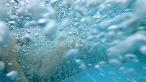 young girl relaxing in hot tub full of underwater bubbles at spa centre