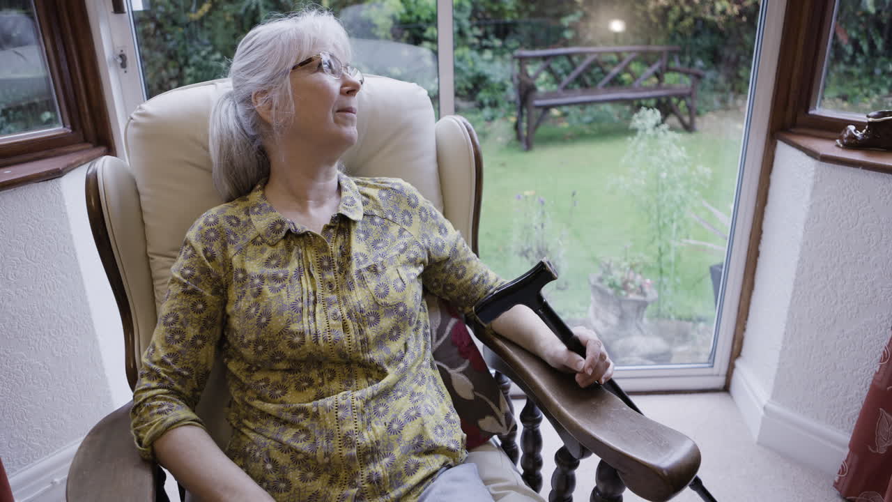 Older woman sitting in armchair by the window