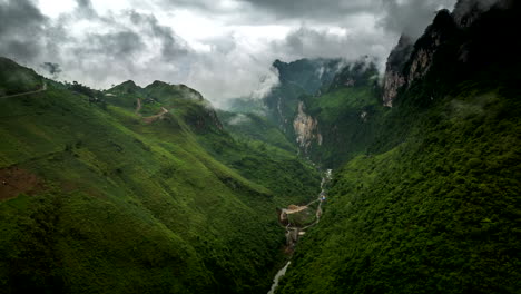 drone hyperlpase of scenic valley with eerie swirling mountain fog around peaks