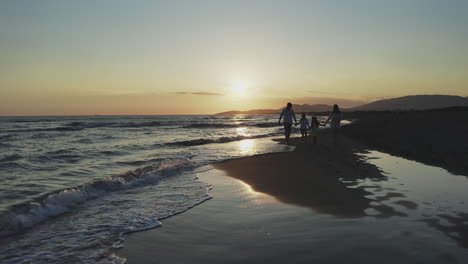 family walk on the beach at sunset