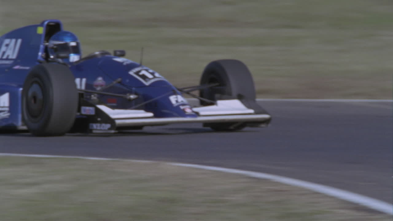 Premium stock video - A race car speeds down a stretch of track