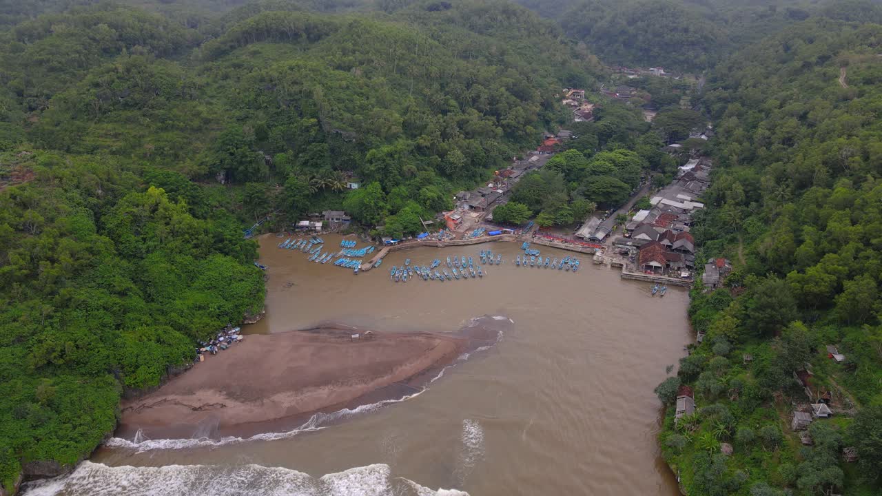 la bahía está rodeada de colinas y bosques que se utilizan como puerto para barcos de pesca - playa baron, yogyakarta, indonesia