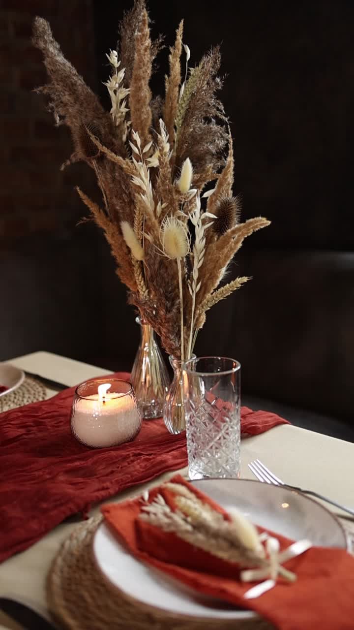 Elegant Table Setting with Dried Flowers and Lit Candle