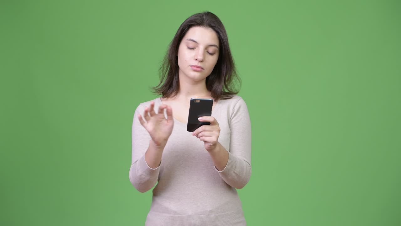 초록색 배경 에 전화 를 사용 하는 아름다운 젊은 여자