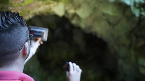 grabando algunos sonidos ambientales con un dispositivo de grabación tomado frente a una cueva en la ubicación de la tumba de la diosa bastet ubicada en el bosque de la montaña strandzha en bulgaria