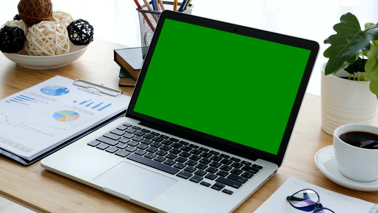 4K : A laptop computer with a key green screen set on work office table.