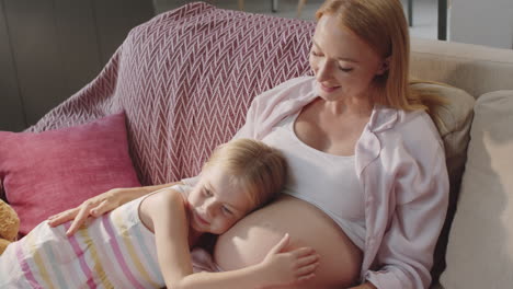 happy pregnant mother with daughter