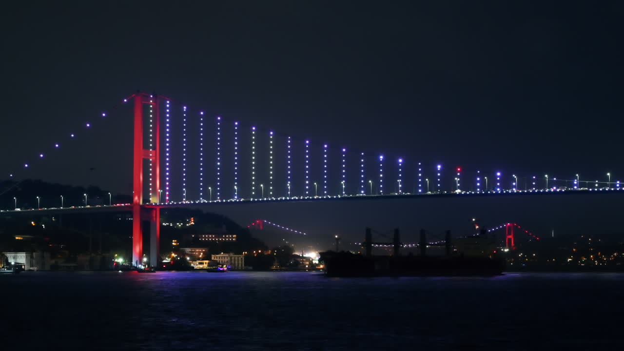 Udsigt over Bosporusbroen om natten i Istanbul, Tyrkiet. Set fra et flydende skib med belysning og biler i bevægelse på broen