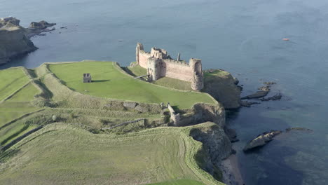 An-aerial-view-of-the-front-and-side-of-Tantallon-Castle-ruin-on-a-sunny-day,-East-Lothian,-Scotland