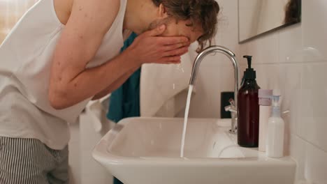 man washing hands in bathroom