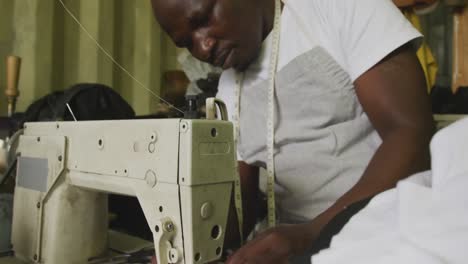 hombre africano preparando el hilo para coser