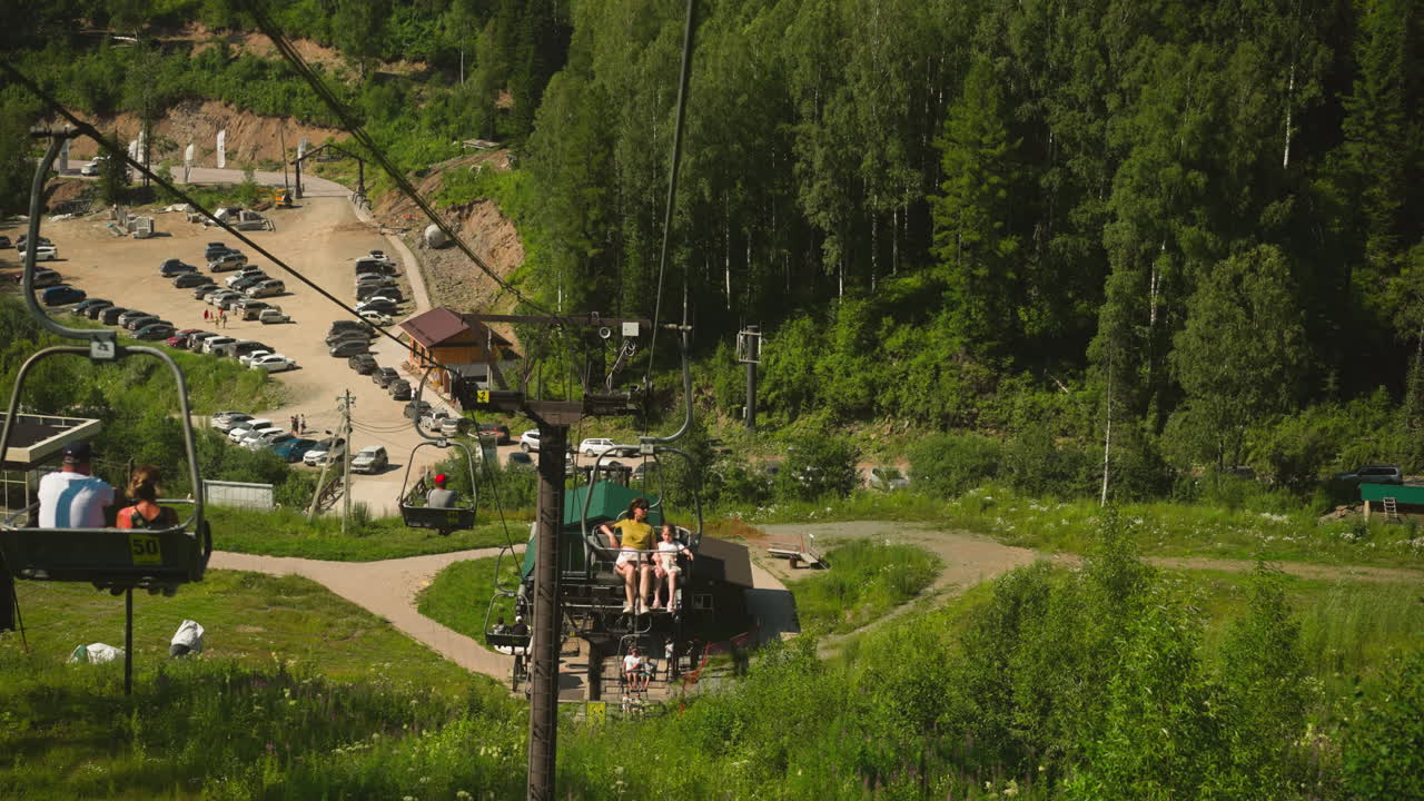 Joyful family rides cable car with incredible view of nature beauty. Enjoying leisure time together on summer holiday. Hotel area surrounded by mountains and forest slow motion