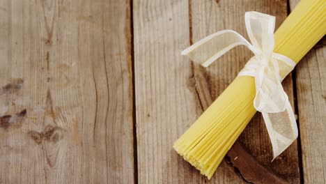 bunch of raw spaghetti tied up with white ribbon