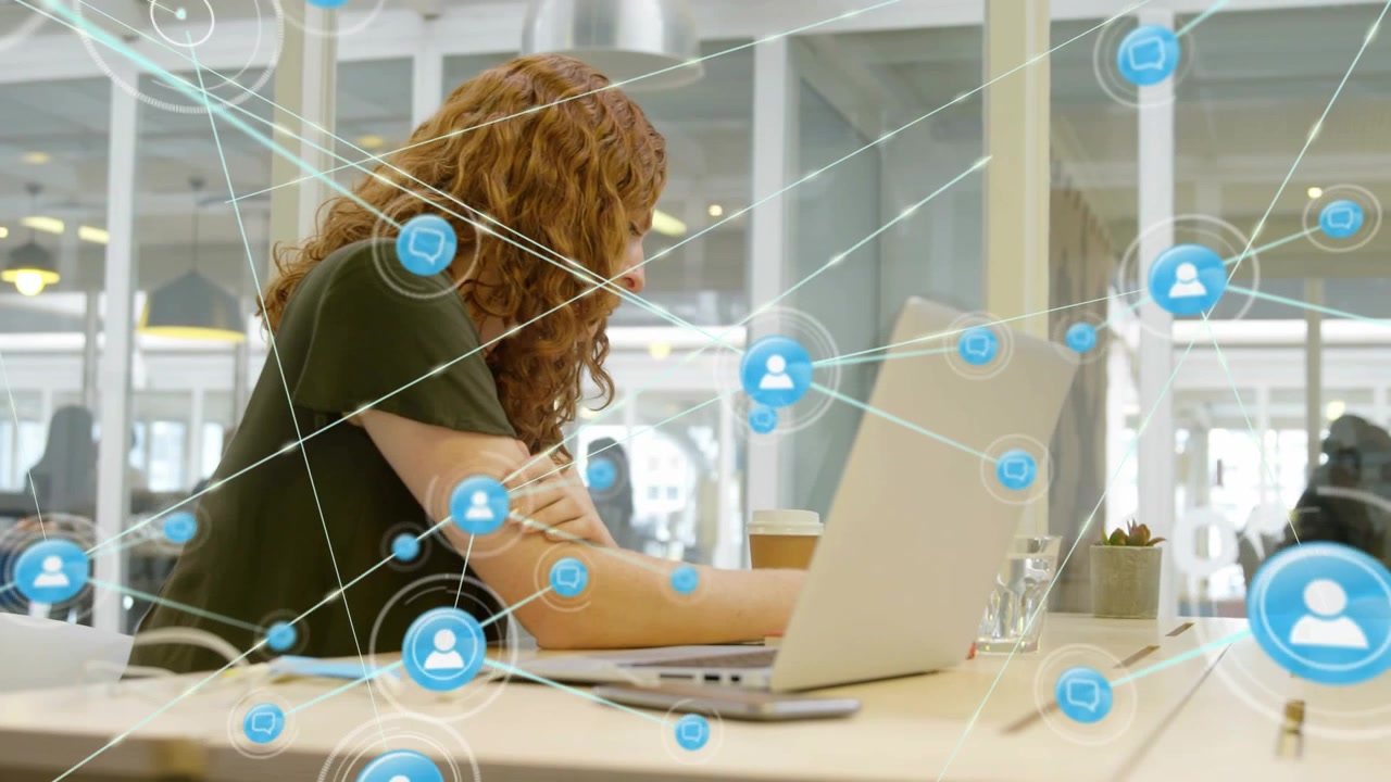 Woman lifting hand then typing laptop, initiating tech AR network of blue icons overlaying desk