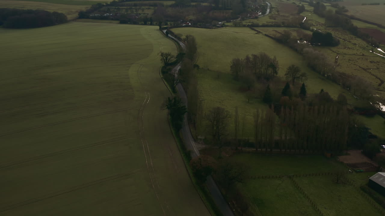 Aerial drone tilting up to reveal the country road amongst a vast landscape