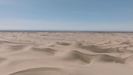 Fliegen-über-Weite-Und-Majestätische-Offene-Wüstenlandschaft,-Luftdrohne-Mit-Blauem-Himmel-Und-Weichem-Sand