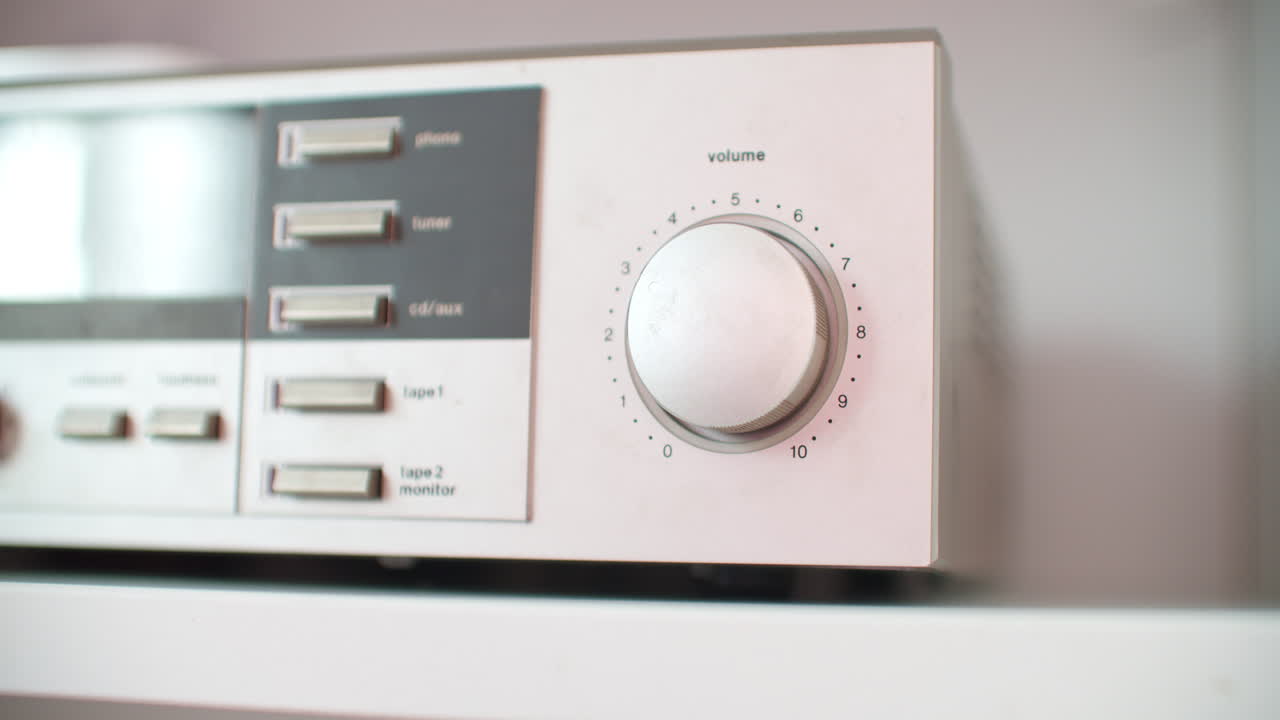 실버 사운드 장치에서 볼륨을 조정하는 낮은 각도 클로즈업 샷