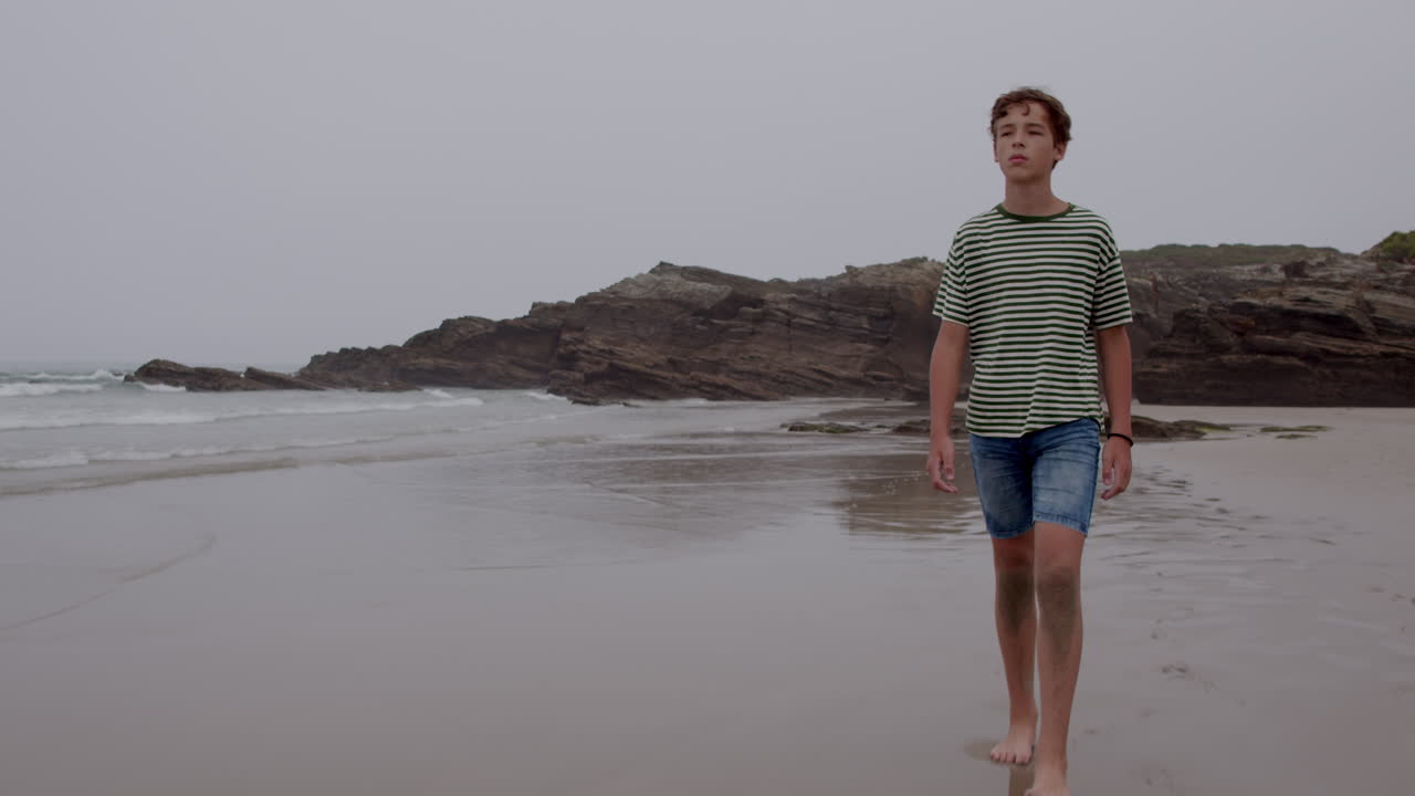 Teenager går på en strand