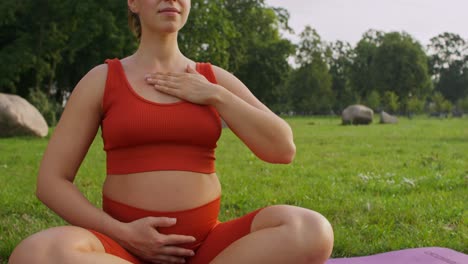 mujer embarazada meditando al aire libre