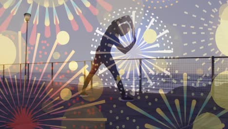 fireworks icons against african american fit man performing stretching exercise at the promenade