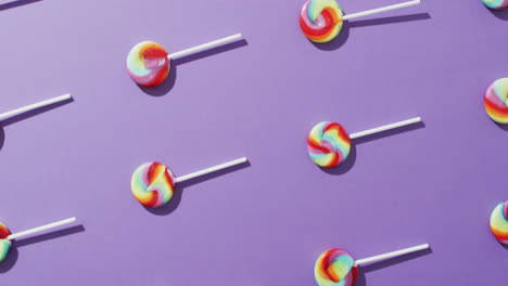 Video-of-rows-multicoloured-lollipops-on-blue-background