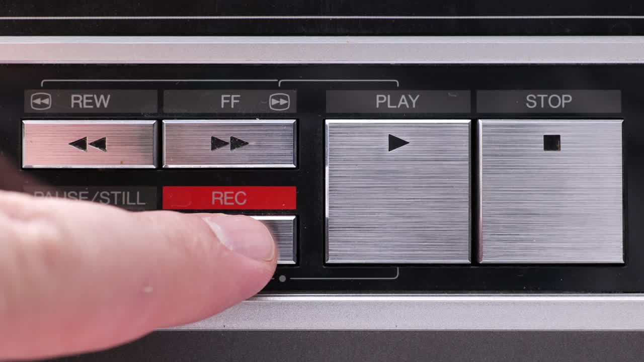 Extreme close up of buttons on an old antique or vintage VCR, Pushing and holding the Record button