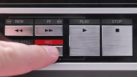 extreme close up of buttons on an old antique or vintage vcr, pushing and holding the record button