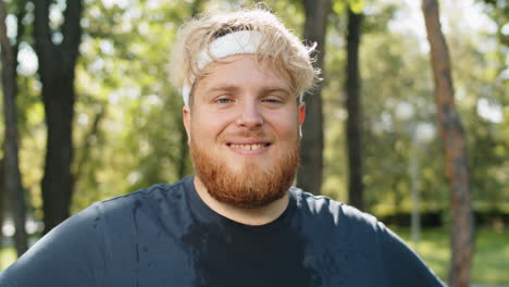 portrait of cheerful overweight man after jogging in park