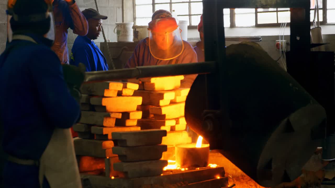 Male worker mixing molted metal in container at workshop 4k