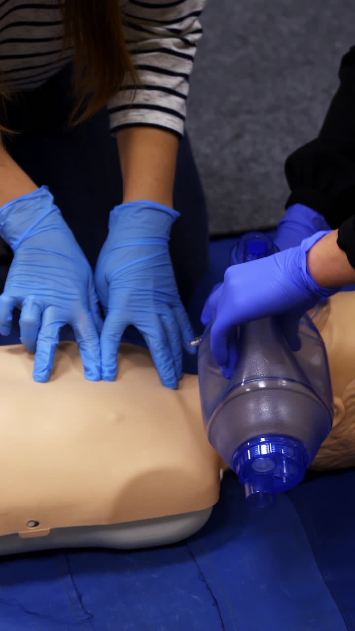 First aid training indoors. People learning how to save life when the baby is choked with instructor. Vertical video