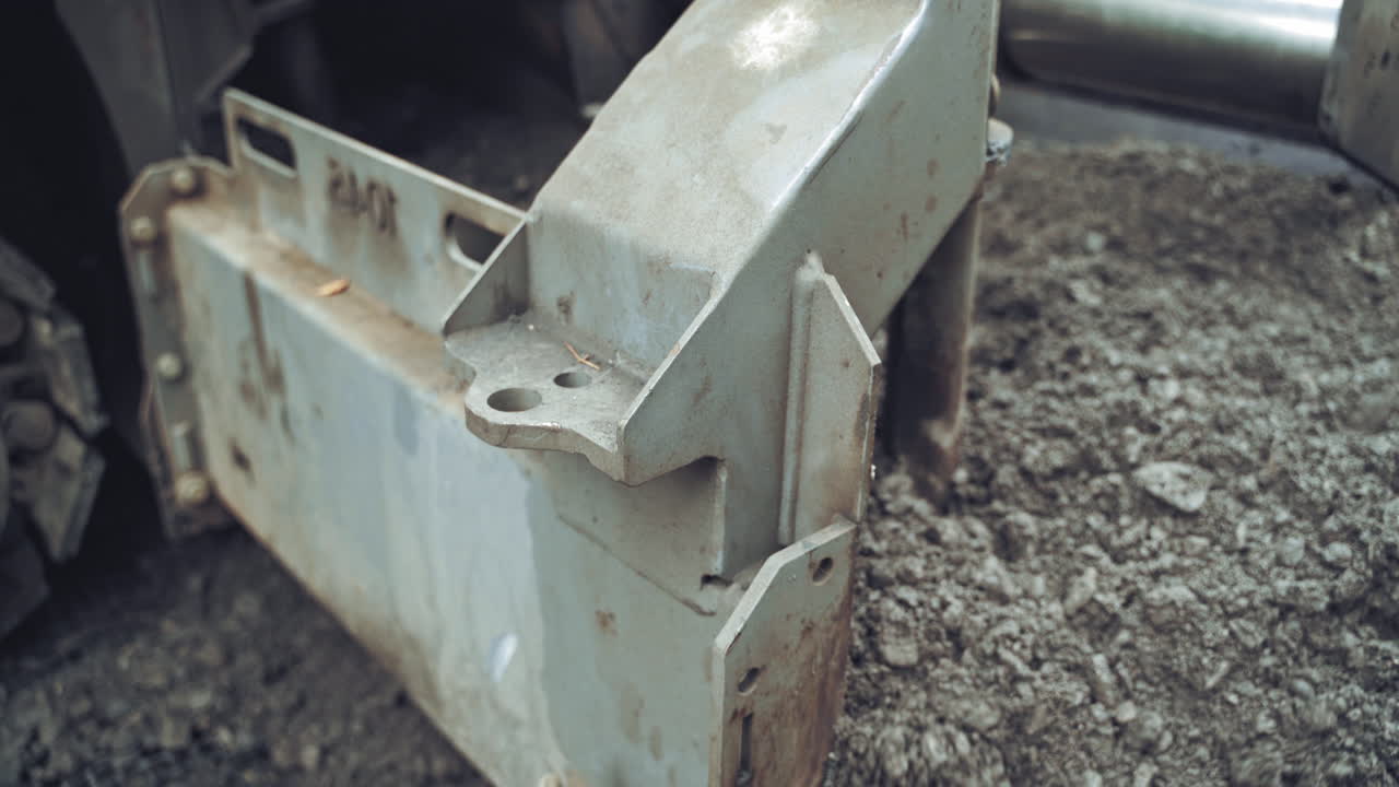 Road construction machinery pouring out new asphalt into the ground. Roadworks repaving process. Road construction. Close-up