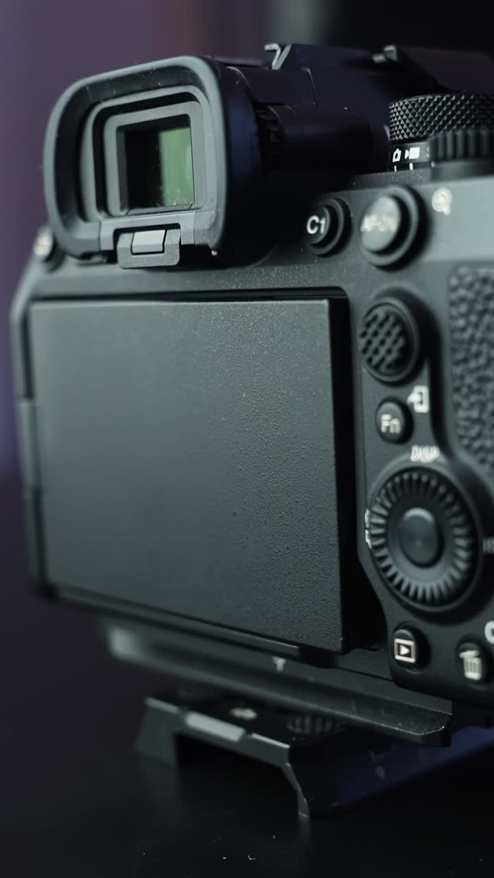 Close-up of rear mirrorless camera on tripod with blank LCD and viewfinder, showcasing buttons and command dial in soft studio light with copy space