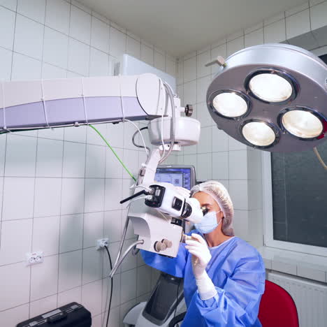 surgeon using operating microscope during work. video from the side. modern equipment in ophtalmology. selective video focus.