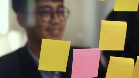 grupo de hombres creativos asiáticos taller y lluvia de ideas delante de la junta de espejo. joven equipo de negocios profesionales trabajando crear estrategia, situación de negocios, puesta en marcha en el concepto de oficina loft. cámara lenta.